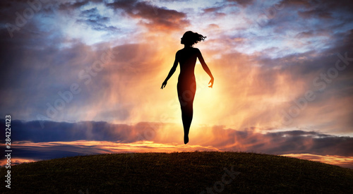 Silhouette of Woman Rising into Heaven. Levitation. Have a positive mindset. photo