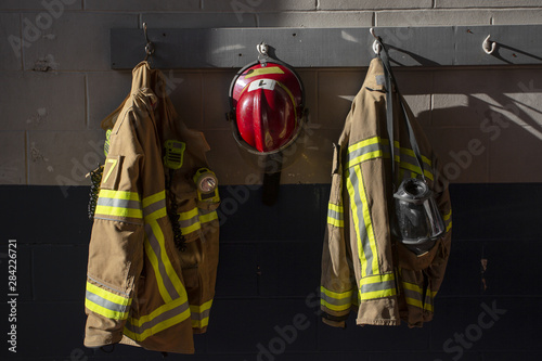 Fotografia Firefighter protection gear hanging on fire station wall