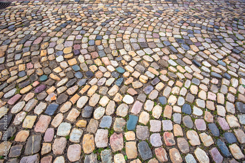 Fototapeta premium Colorful cobblestone pattern on old European cobbled street