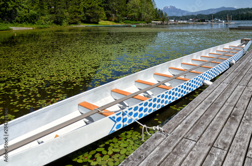 Fototapeta beautiful long wooden white boat at a wooden pier on a picturesque Sproat Lake o