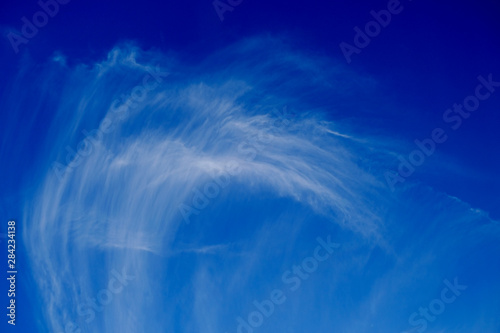 Spectacular horse mare cloud in perfectly blue sky, high cirrus cloud made up of small ice particles scattered by upper winds, polarized.