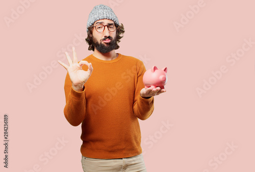 young bearded man with a piggy bank photo
