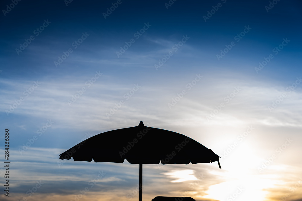 Silhouette of beach umbrella against backlight on a hot summer day.