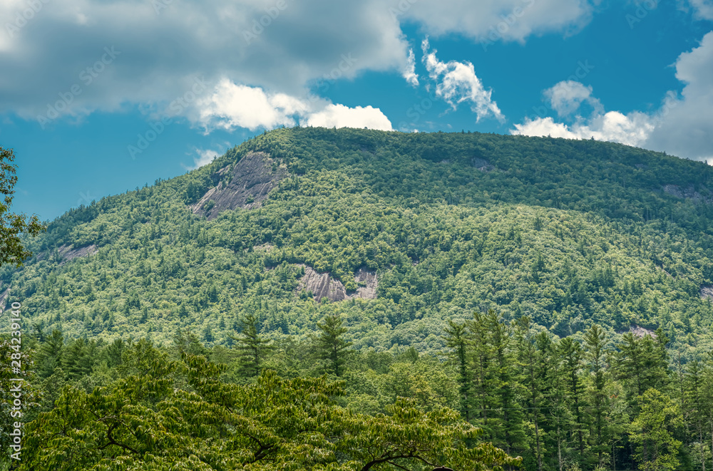 A blue sky over a wooded mountain in the Blue Ridge Mountains in North Carolina.