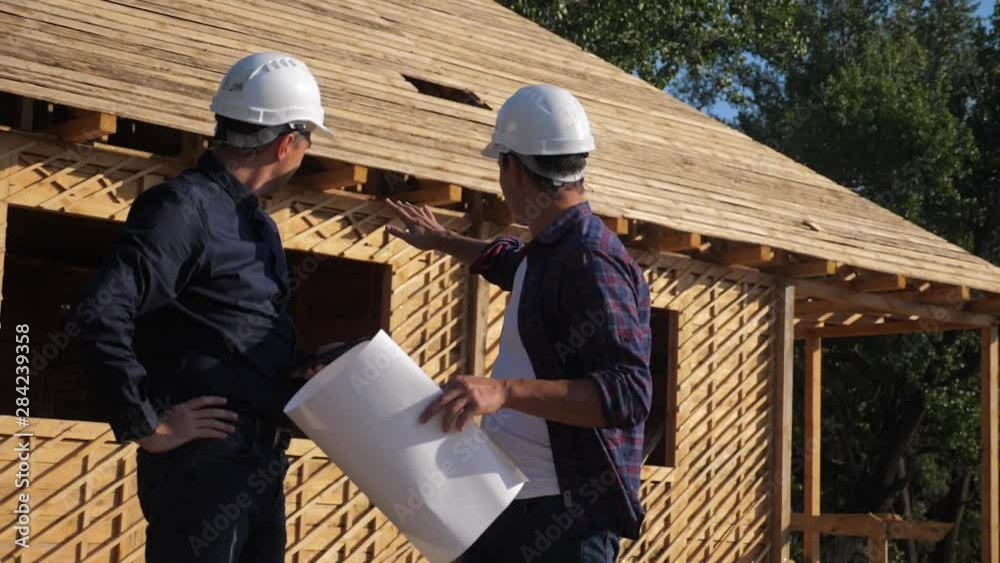 teamwork. concept building constructing architect slow motion video. two men builder in helmets study the house plan. two architects working on the construction of a frame house business contrast at teamwork. concept building constructing architect slow motion video. two men builder in helmets study the house plan. two architects working on the construction of a frame house business contrast at