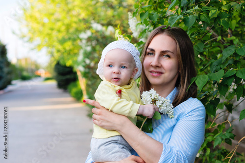 Young loving mother on maternity leave. Mother and cute toddler daughter enjoy a walk. Happiness to be a parent. Relaxing outdoors. photo