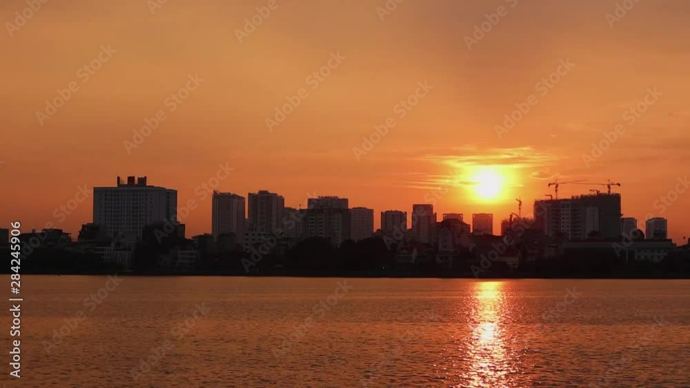 peaceful time lapse shot of the city over the lake. Hanoi Vietnam is in the picture. West lake the largest lake in Hanoi. peaceful time lapse shot of the city over the lake. Hanoi Vietnam is in the picture. West lake the largest lake in Hanoi.