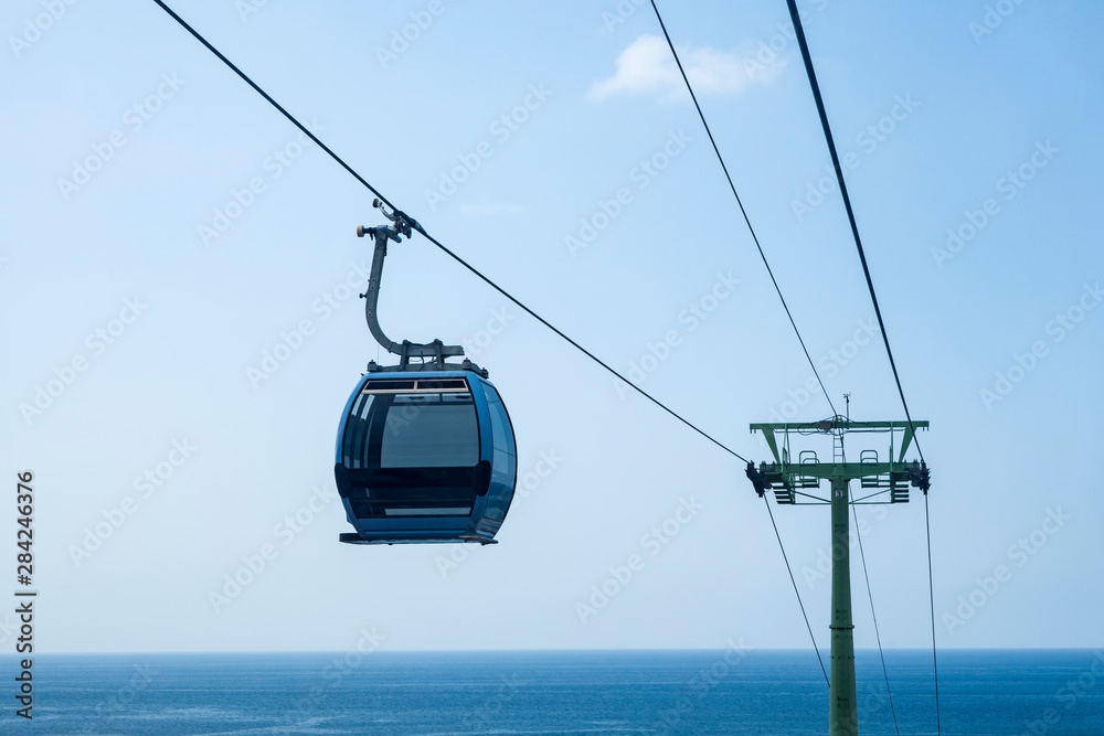 Cabin cable car close-up against the ocean. The background of the image is blue. Copy space. Cabin cable car close-up against the ocean. The background of the image is blue. Copy space.