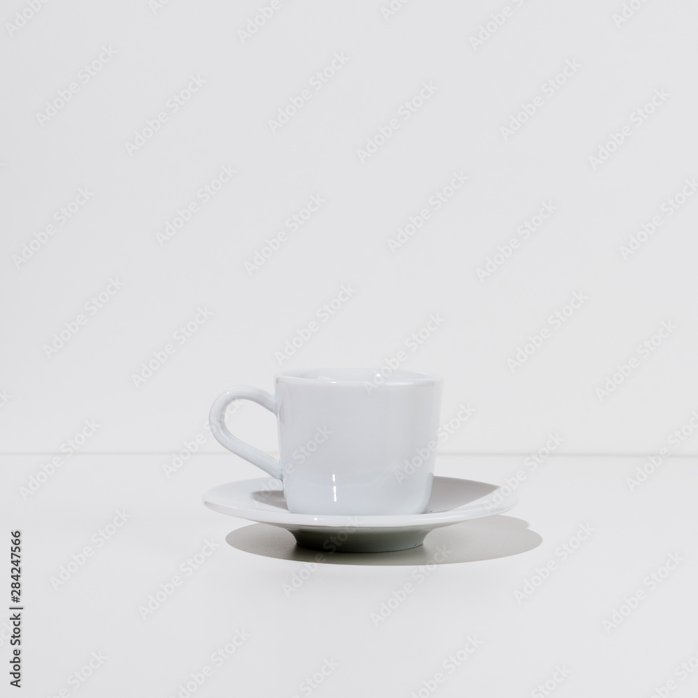 White cup and saucer on a table, selective focus, square image White cup and saucer on a table, selective focus, square image