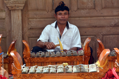 Indonesian man playing traditinal gamelan music in Bali Indonesia photo