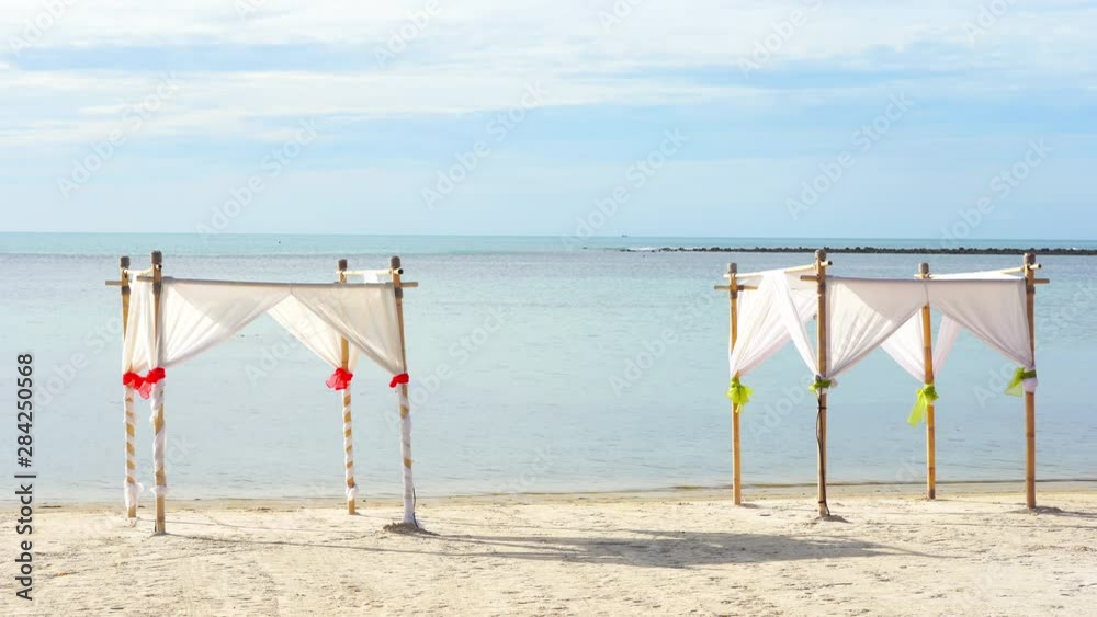 A couple of simple white canvas sunshades on a dreamy tropical beach A couple of simple white canvas sunshades on a dreamy tropical beach