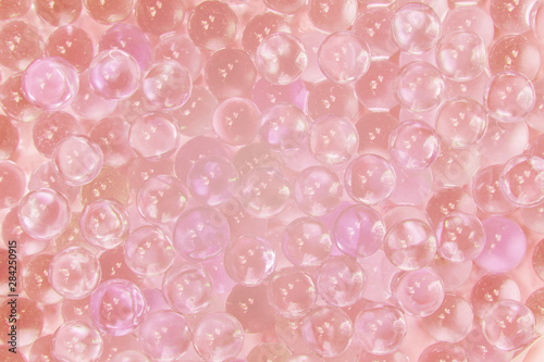 Abstract texture of transparent glass balls with pink ink or lump of marbles. Collagen Hydrolysate. Hyaluronic acid skin solutions ad, collagen serum drop with space cosmetic advertising ready. photo