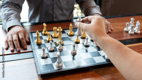 Business man take a king figure checkmate on the chess board game - strategy, management or leadership success concept.