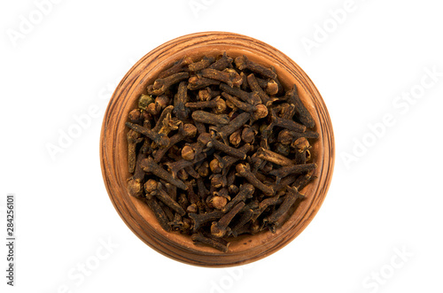 Dry cloves in glossy cup isolated on white background. View from above. Seasoning on isolate. Dry spices.