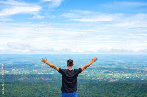 Asian man raise their arms on the point of view of the mountains at Patio stone button in Phu Hin Rong Kla National Park ,Phitsanulok , Thailand.