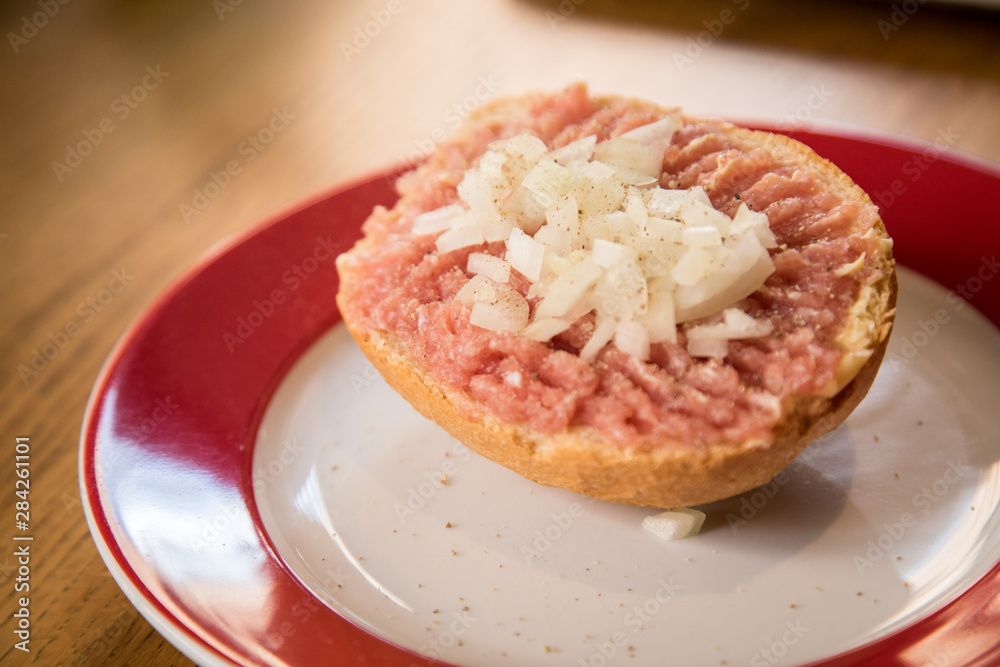 Teller Mettbrötchen mit Mett und Zwiebeln auf Holz Tisch Teller Mettbrötchen mit Mett und Zwiebeln auf Holz Tisch