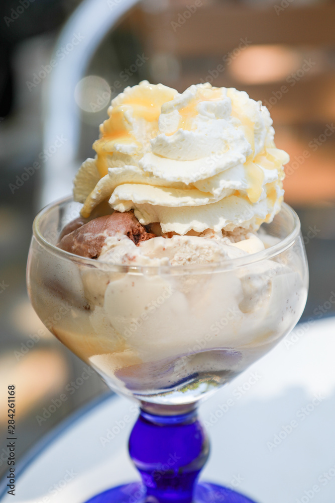 Eisbecher mit Schokolade, Nuss, Sahne und Eierlikör draußen bei Eisdiele Eisbecher mit Schokolade, Nuss, Sahne und Eierlikör draußen bei Eisdiele