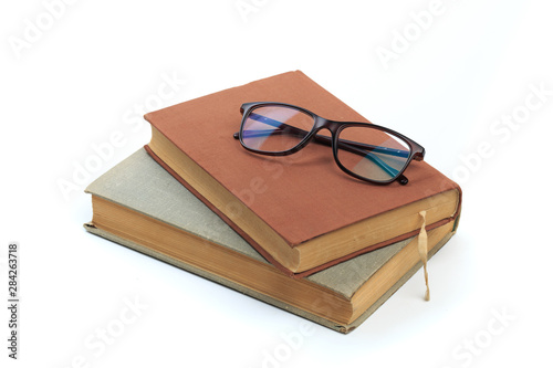 vintage old hardcover books with glasses on white background