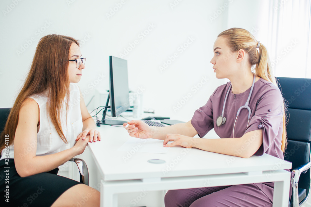 Female doctor in purple uniform giving a consultation to a patient and explaining medical informations and diagnosis Female doctor in purple uniform giving a consultation to a patient and explaining medical informations and diagnosis
