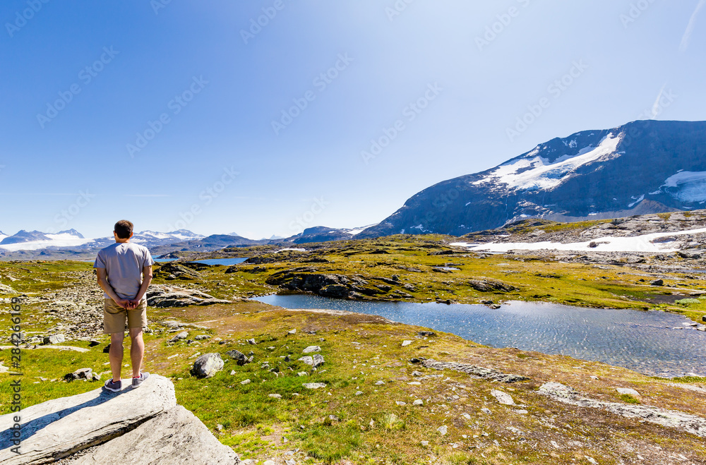 Man enjoying the beautiful landscape along National scenic route Sognefjellet between Skjolden and Lorn in Sogn og Fjordane in Western Norway.