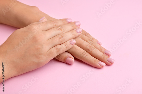 Female hands with beautiful manicure on color background