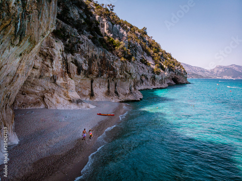 young couple with kayak boat on the ebach of Cala Luna Sardinia Italy photo