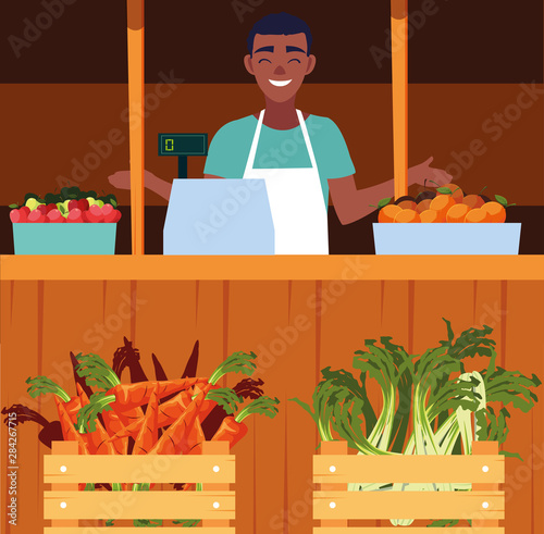 salesman with stall kiosk of store vegetables