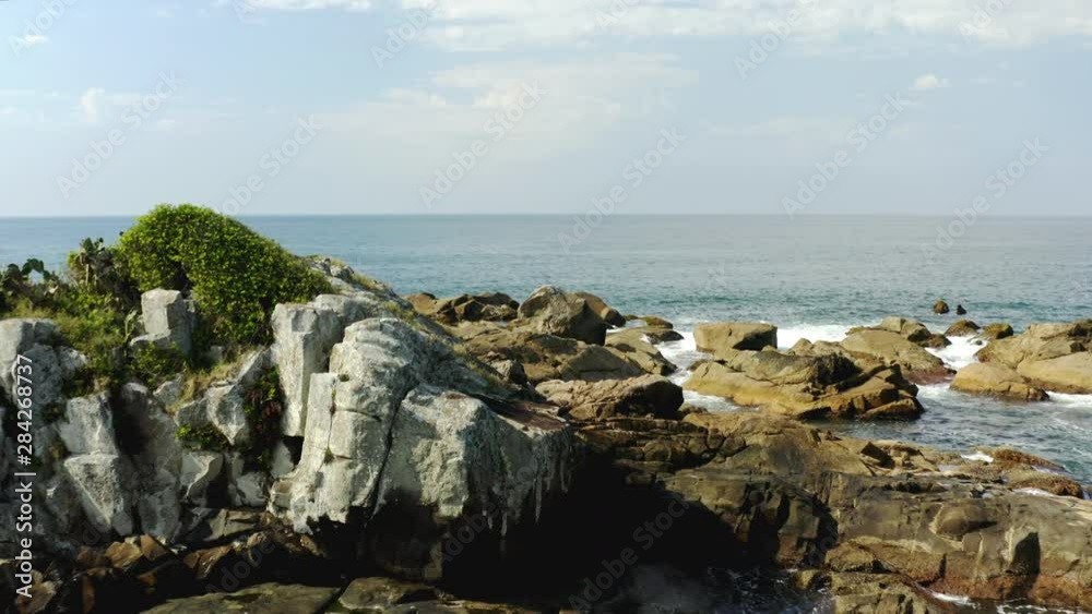 Aerial view of sea waves and ocean at a fantastic rocky coast, Praia Armacao, Florianopolis, Santa Catarina, Brazil Aerial view of sea waves and ocean at a fantastic rocky coast, Praia Armacao, Florianopolis, Santa Catarina, Brazil
