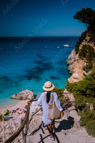 The beautiful bay in the Gulf of Orosei, Sardinia Cala Goloritze, young girl in dress looking out over the beach of Cala Goloritze photo