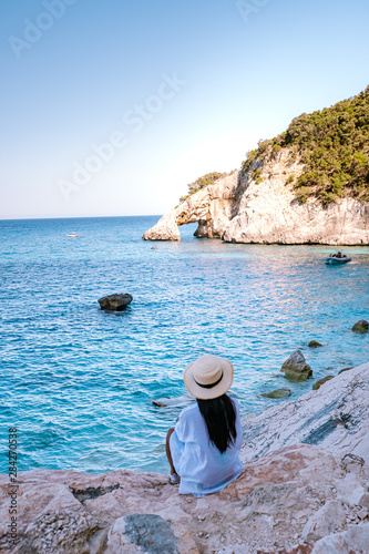The beautiful bay in the Gulf of Orosei, Sardinia Cala Goloritze, young girl in dress looking out over the beach of Cala Goloritze photo