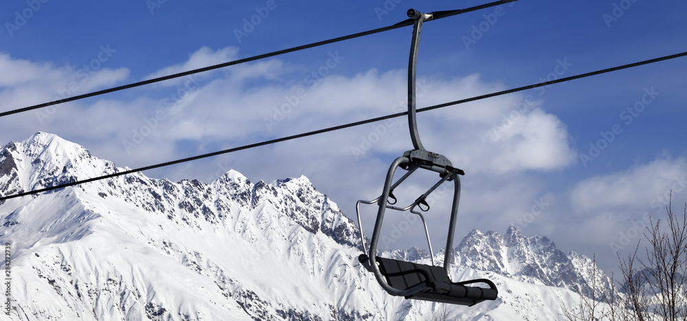 Ski lift in snow winter mountains at nice sunny day