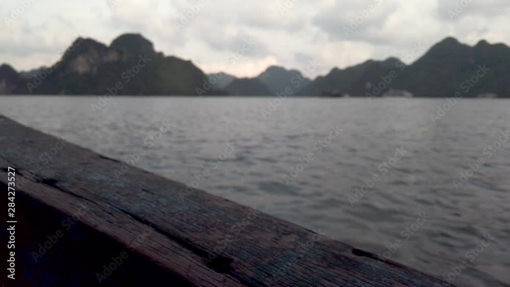 Focus on wood details in Traditional boat crossing sea in Cat Ba Island with rainforest on limestone, stunning destination in southeast asia. Wooden boats sailing emerald water in Halong bay. Focus on wood details in Traditional boat crossing sea in Cat Ba Island with rainforest on limestone, stunning destination in southeast asia. Wooden boats sailing emerald water in Halong bay.