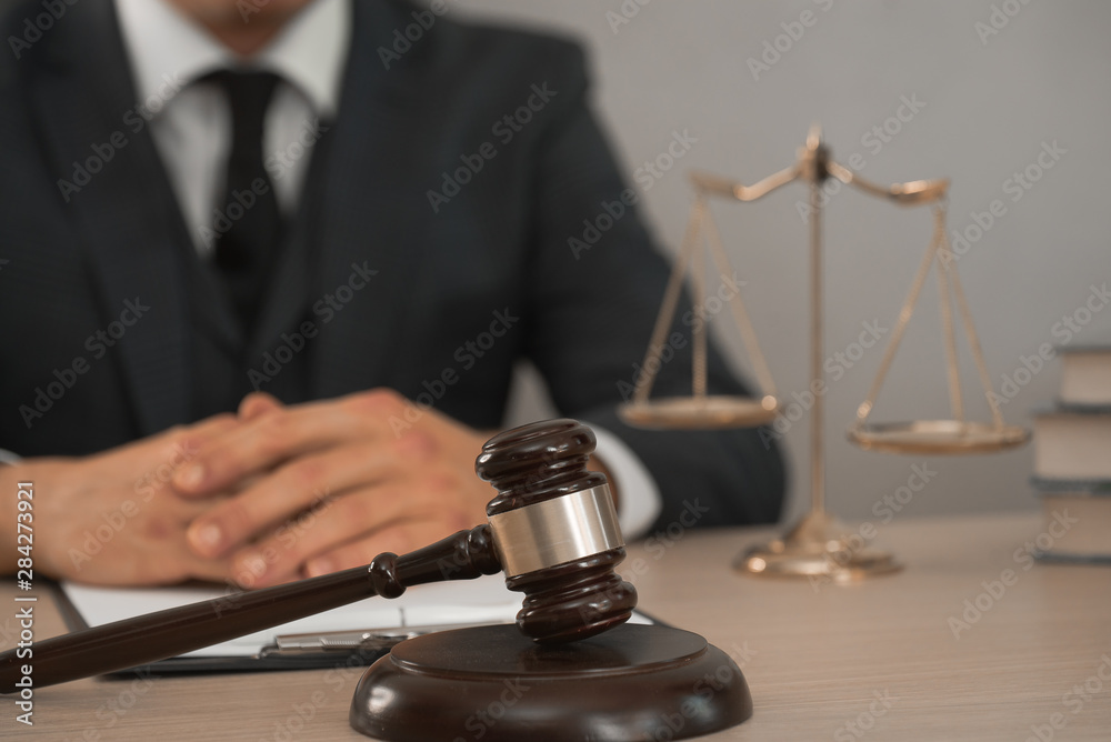 Law and Legal services concept. Male lawyer or judge working with contract papers, Law books and wooden gavel on table in courtroom Law and Legal services concept. Male lawyer or judge working with contract papers, Law books and wooden gavel on table in courtroom