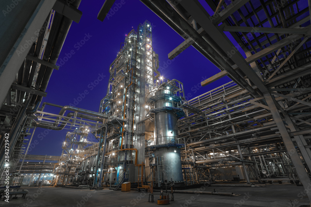 view of metal pipes of illuminated industrial plant outdoor at night 