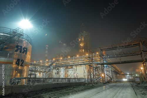 the form of metal pipes of a refinery in the open air at night