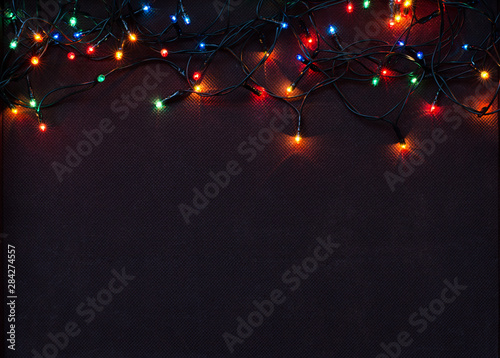 Christmas garland with colorful lights on brown textile