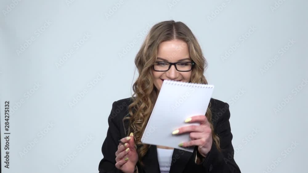 Girl takes pencil, notebook and draws schemes, then happily hugs notebook, slow motion Girl takes pencil, notebook and draws schemes, then happily hugs notebook, slow motion