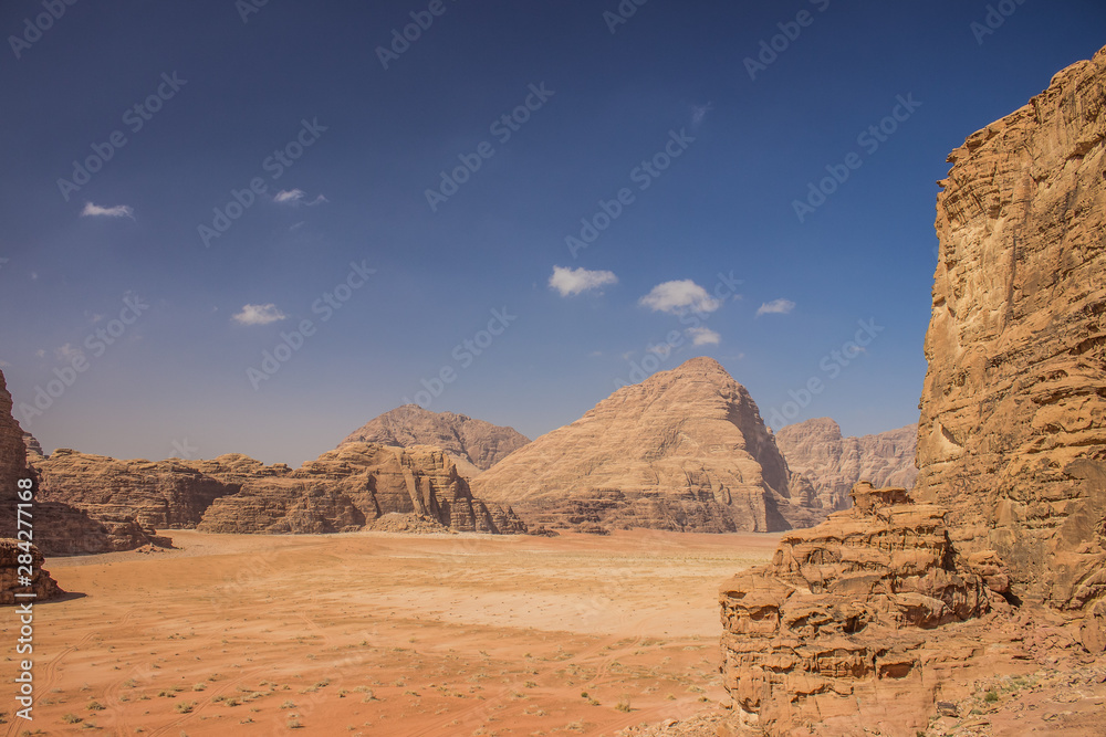 Wadi Rum Jordan desert scenic landscape view with valley surrounded by sand stone rocky mountains 