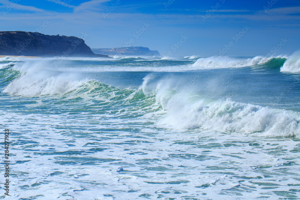 A huge waves on the ocean coast in a shine bright light  at sunny day. Wonderful romantic seascape of ocean coastline.