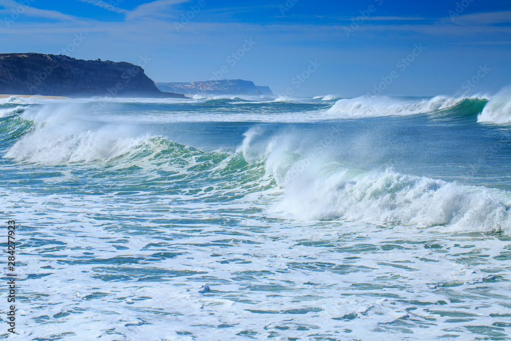 Fototapeta premium A huge waves on the ocean coast in a shine bright light at sunny day. Wonderful romantic seascape of ocean coastline.