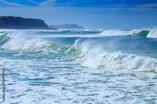 A huge waves on the ocean coast in a shine bright light at sunny day. Wonderful romantic seascape of ocean coastline.