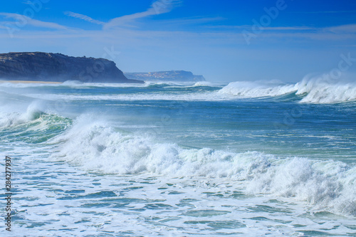 A huge waves on the ocean coast in a shine bright light at sunny day. Wonderful romantic seascape of ocean coastline.