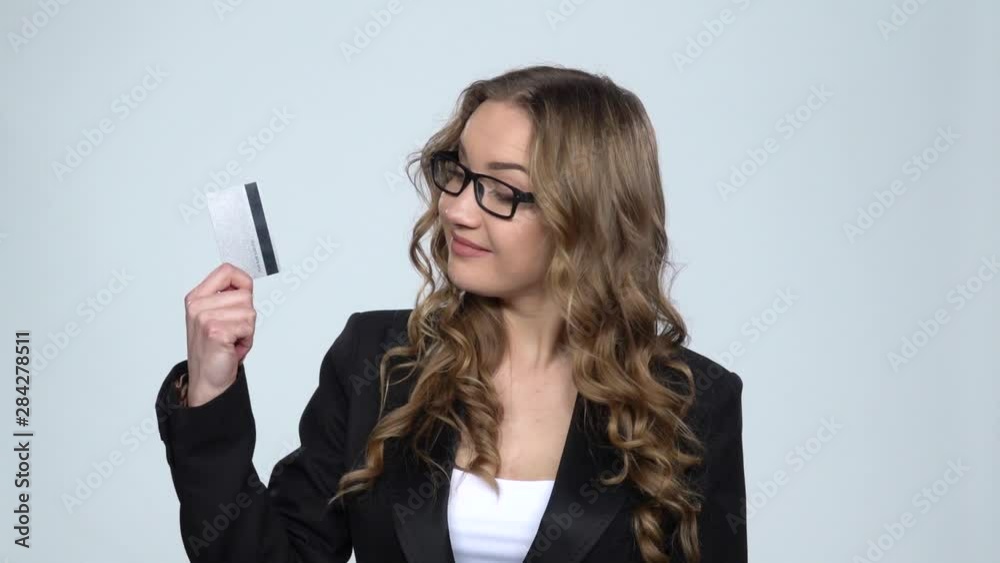 Girl holds credit card and takes cash choosing between them nods approvingly at dollar banknotes, slow motion Girl holds credit card and takes cash choosing between them nods approvingly at dollar banknotes, slow motion
