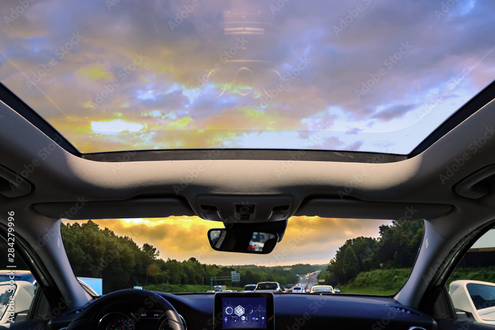 a car sunroof and sunset