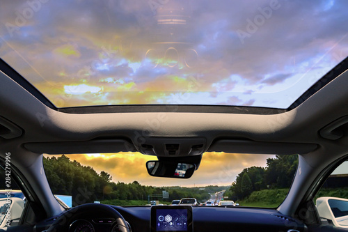 a car sunroof and sunset