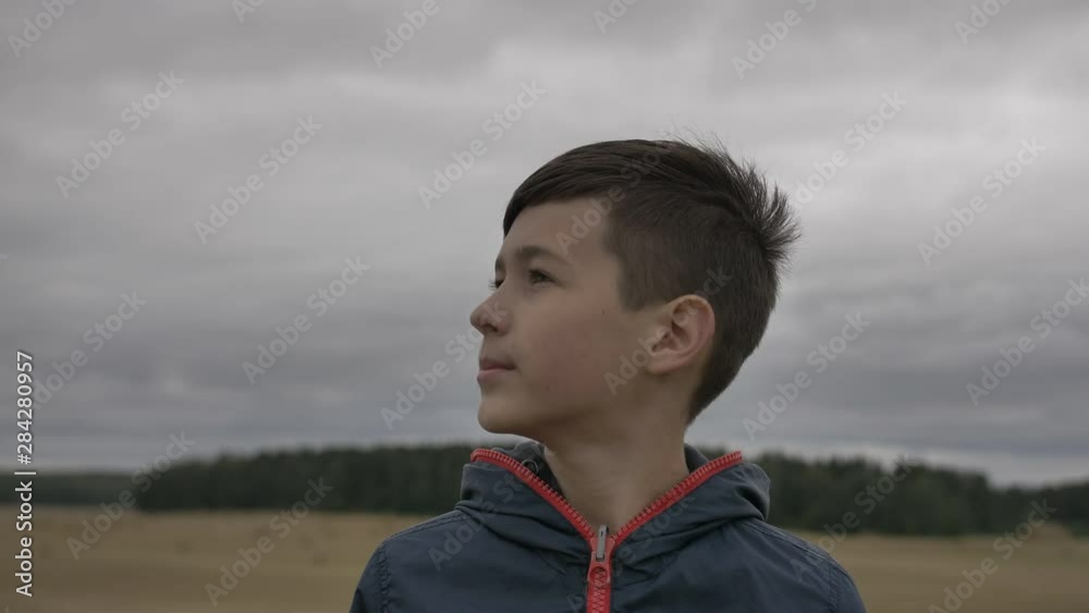 funny dreamer boy looks at the sky outdoors, cloudy weather funny dreamer boy looks at the sky outdoors, cloudy weather