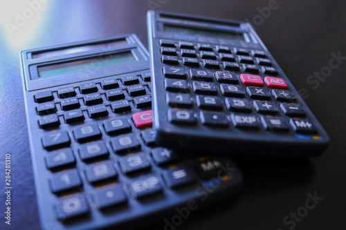 Due calcolatrici su sfondo nero, oggetti da ufficio