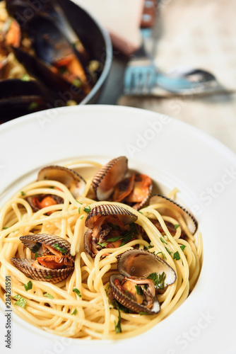 delicious pasta with mollusks in white round plate