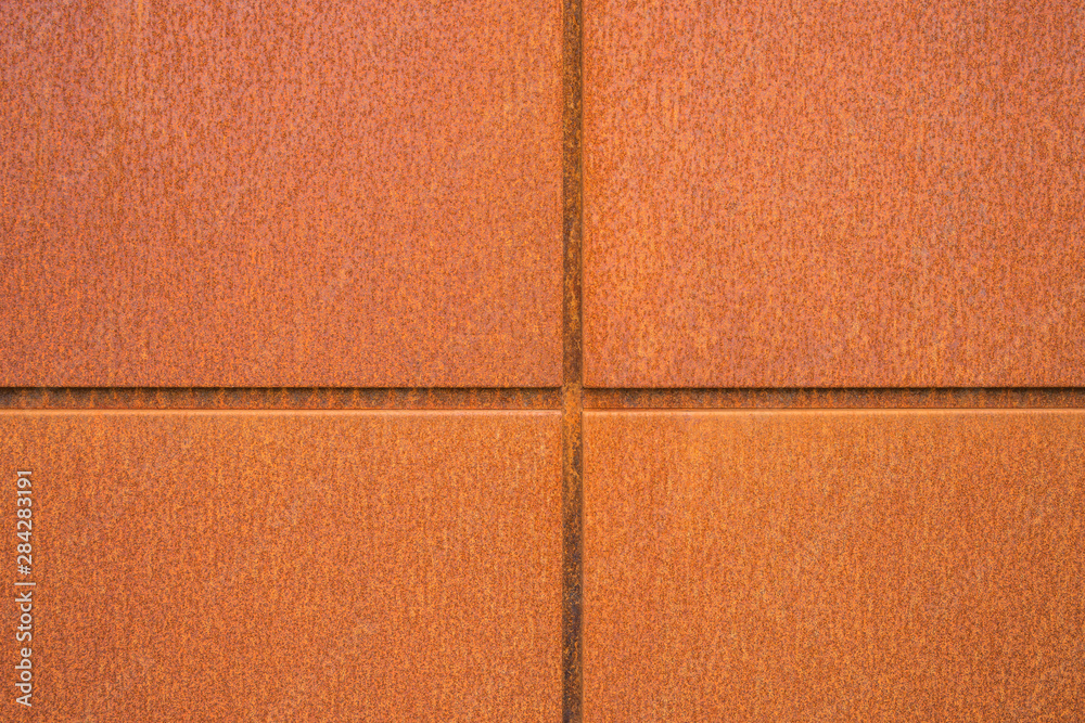 Fototapeta premium Cortenstahl Hintergrund Fassadenplatten aus Eisenblech closeup mit Rost im Industrie Stil - Background facade panels of iron sheet closeup with rust in industrial style
