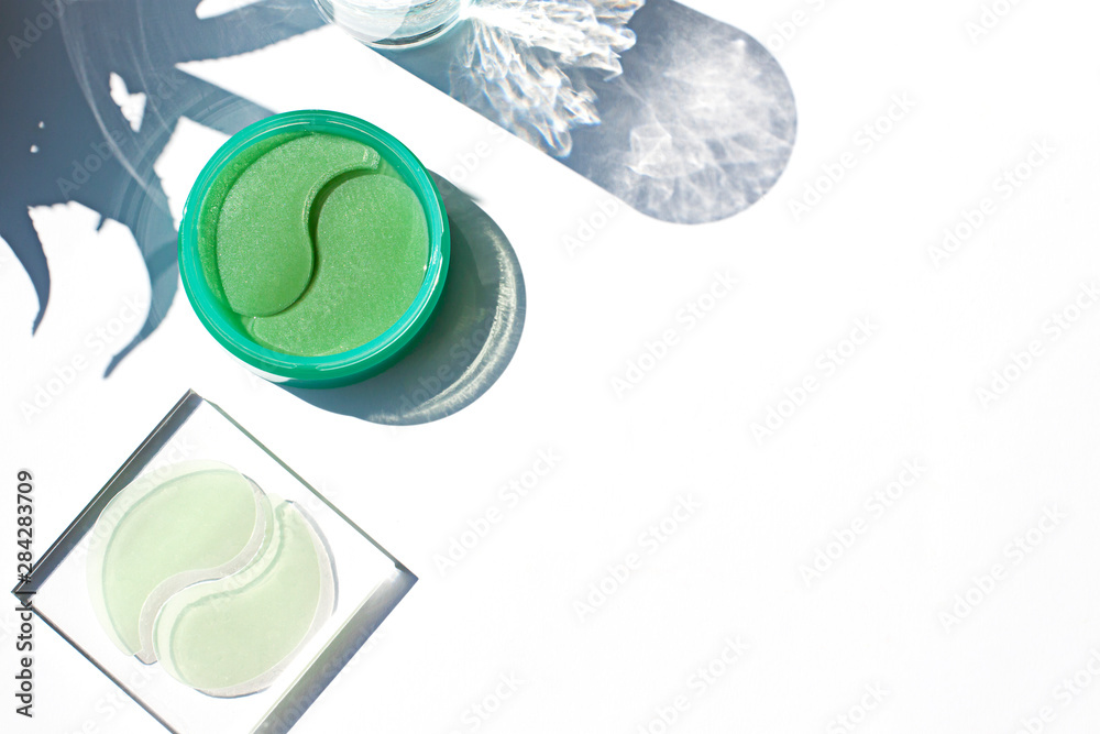 Under eye dark circles hydrogel patches with aloe vera on the sunny white background. Copy space Under eye dark circles hydrogel patches with aloe vera on the sunny white background. Copy space